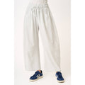 soft and comfortable Light gray barrel sweatpants worn by a person in sneakers on a white background