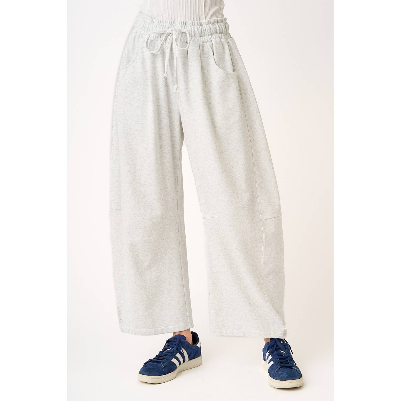 soft and comfortable Light gray barrel sweatpants worn by a person in sneakers on a white background
