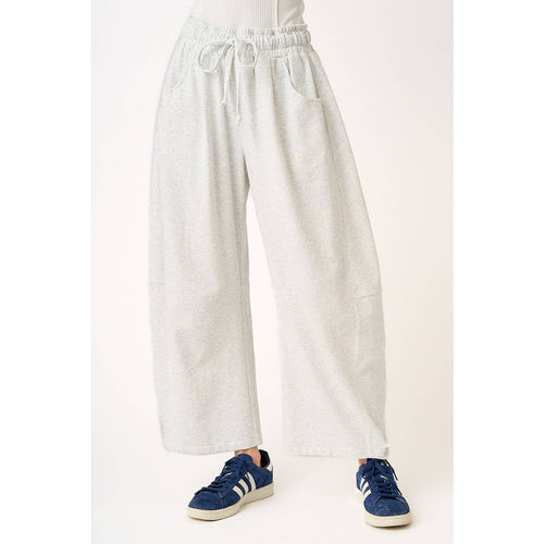 soft and comfortable Light gray barrel sweatpants worn by a person in sneakers on a white background