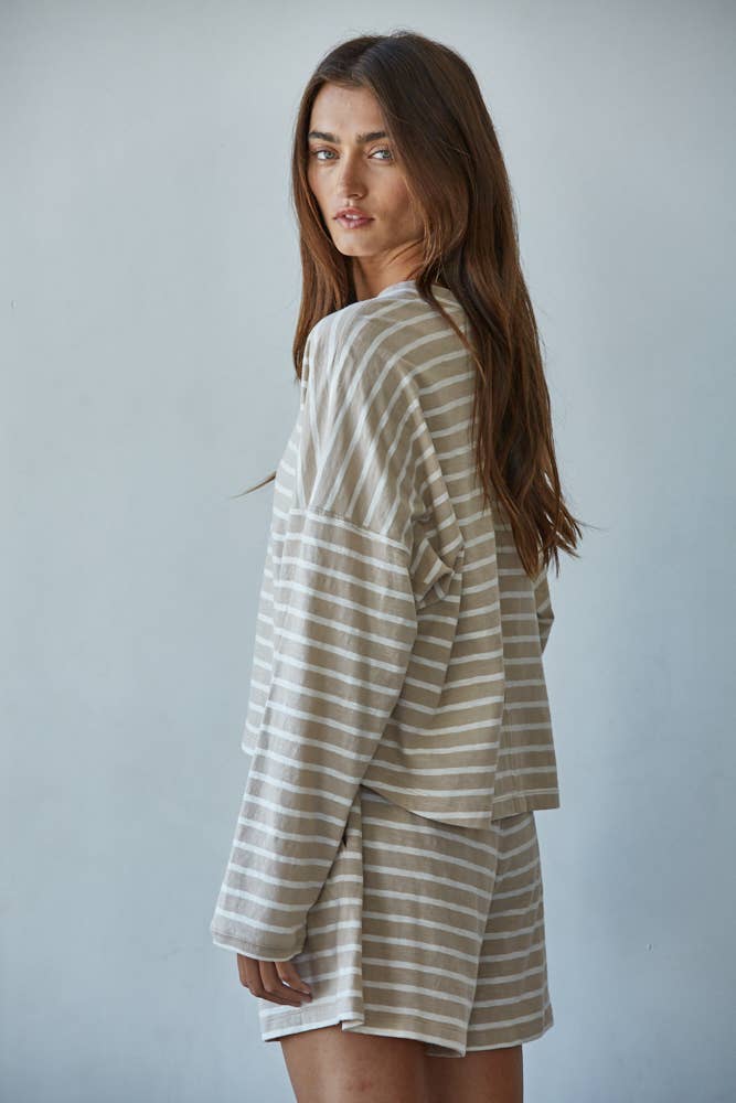 Woman wearing a striped outfit against a plain background