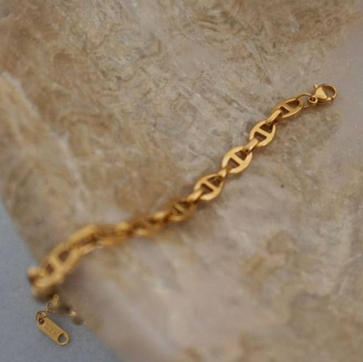 Gold bracelet on a textured stone surface