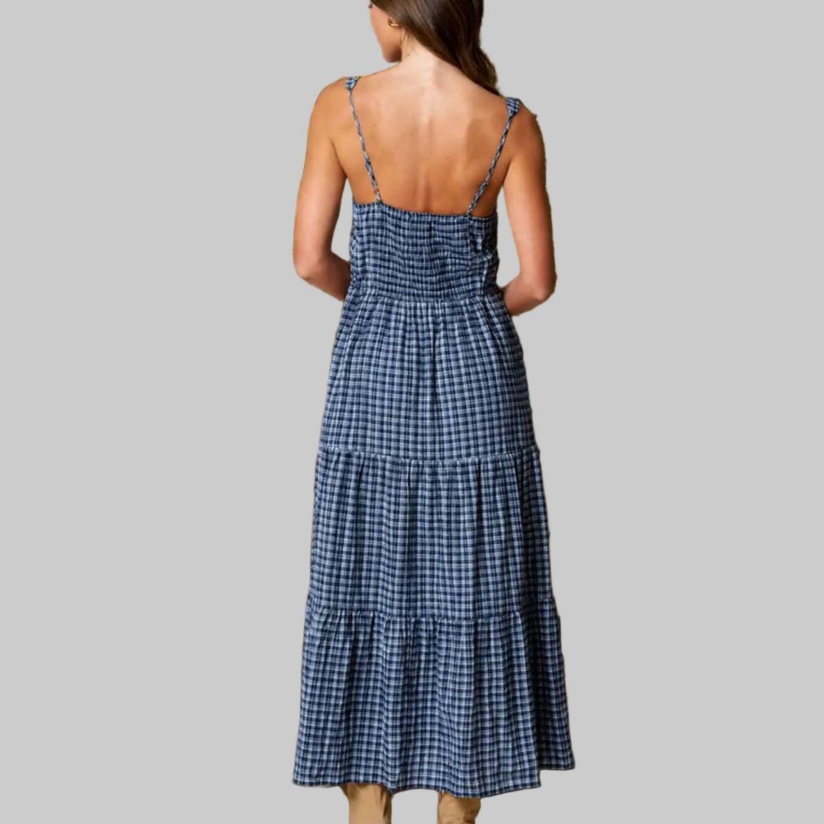 Woman in a blue checkered midi-length dress grey background