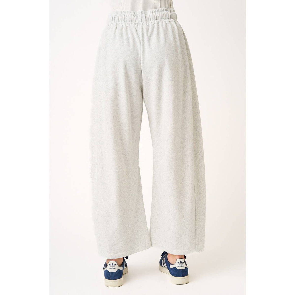 Light gray sweatpants worn by a person on a white background